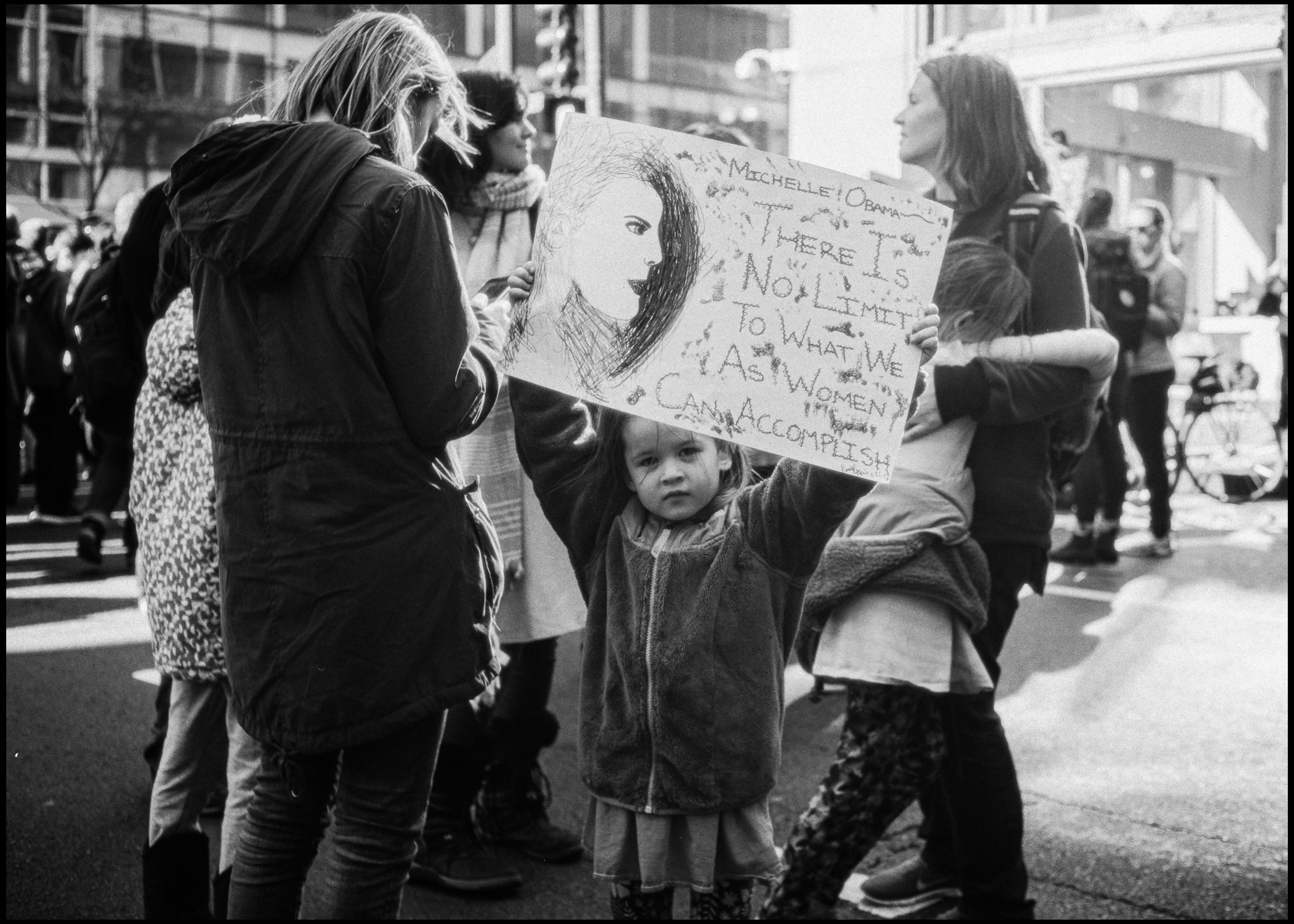Kid holding a Michelle Obama quote sign, Chicago 2017